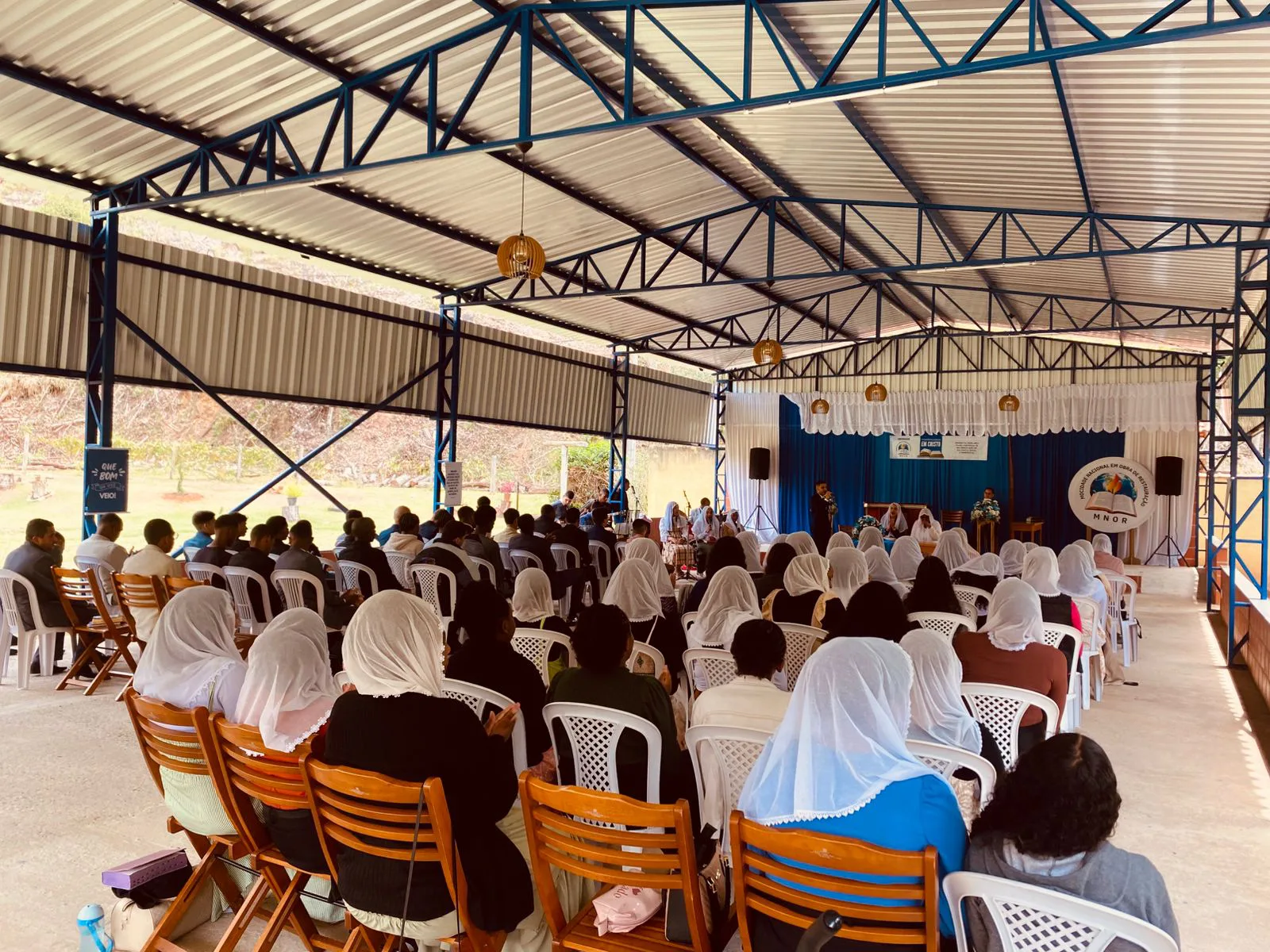 Igreja reunida em culto de louvor e ministração no pavilhão coberto