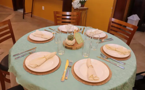 Mesa redonda decorada com toalhas e arranjos no salão