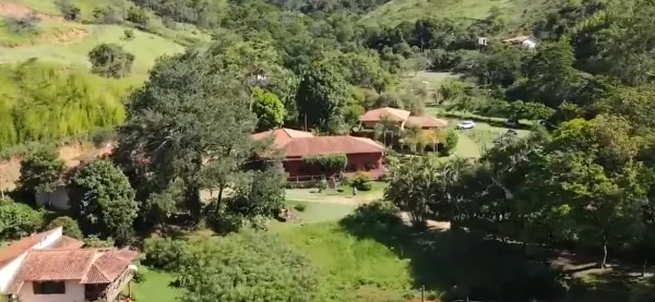 Vista do alto do sítio, com a mata da serra e os chalés no vale